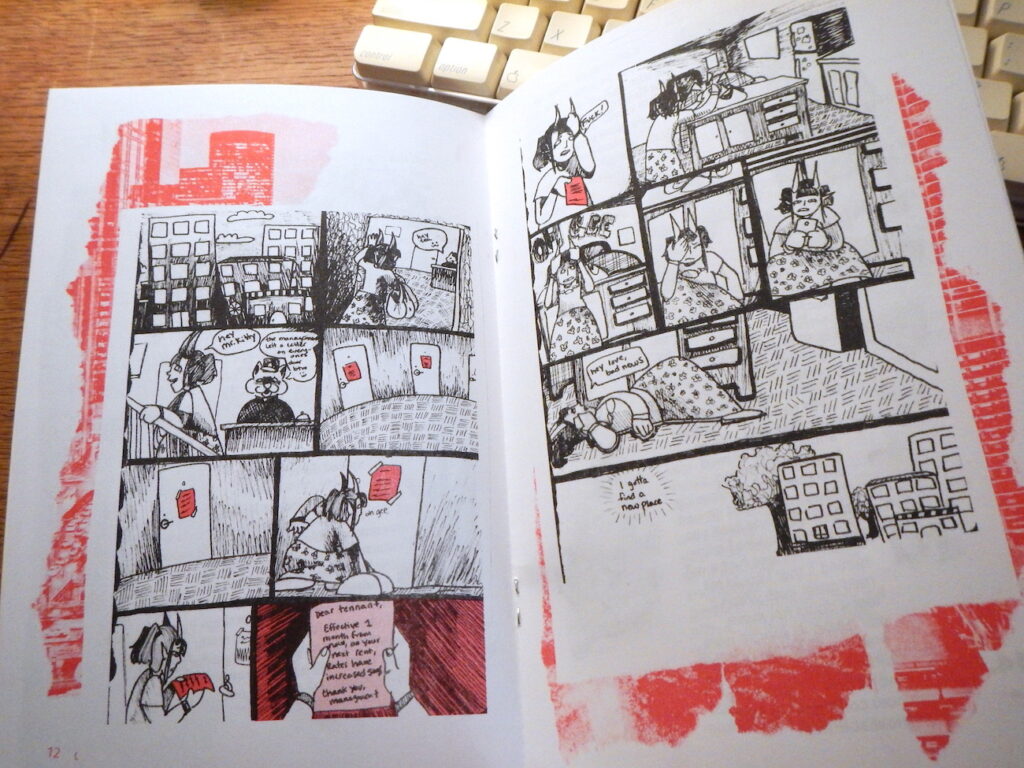 Zine open to a page with a comic printed in black and red