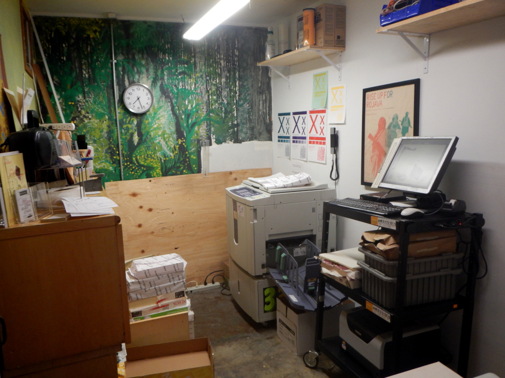 Photo of print room with printer, computer and paper reams